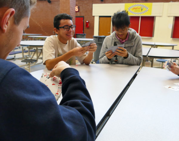 Juniors Jordan Alvarenga (background left) and Kenny Luong (background right) play a card game with senior (foreground) in a moment of relaxation before Thanksgiving Break. Students will not have school from Wednesday, November 22 to Sunday, November 26.