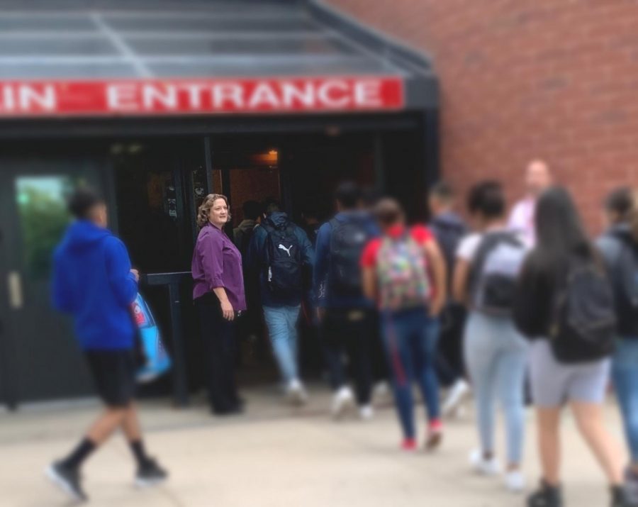 Lisa Grosz stands outside at the front doors before first period. She greets each student as they walk inside to begin their day. (Caroline Smith)