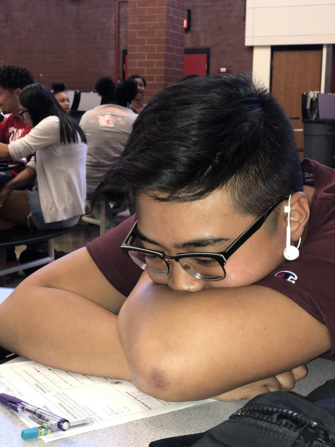 Junior Thien Nguyen sits in the commons. He is stressed out for his honors math final. (Samrawit Kopessa)