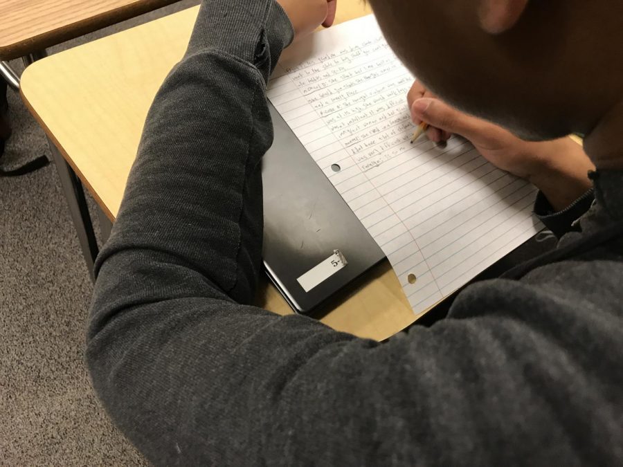 A sophomore student is seen doing work in his honors English class. Some students can feel overwhelmed or stressed due to a high level of honors classes and a pressure to succeed. (Dylan Tressider)