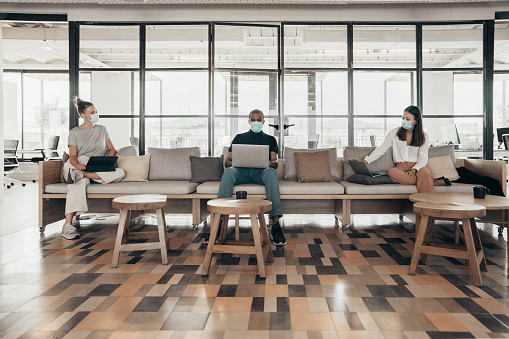   Business people working during the pandemic, while social distancing and wearing face masks to prevent the spread of COVID-19. Photo courtesy of Pixabay. 