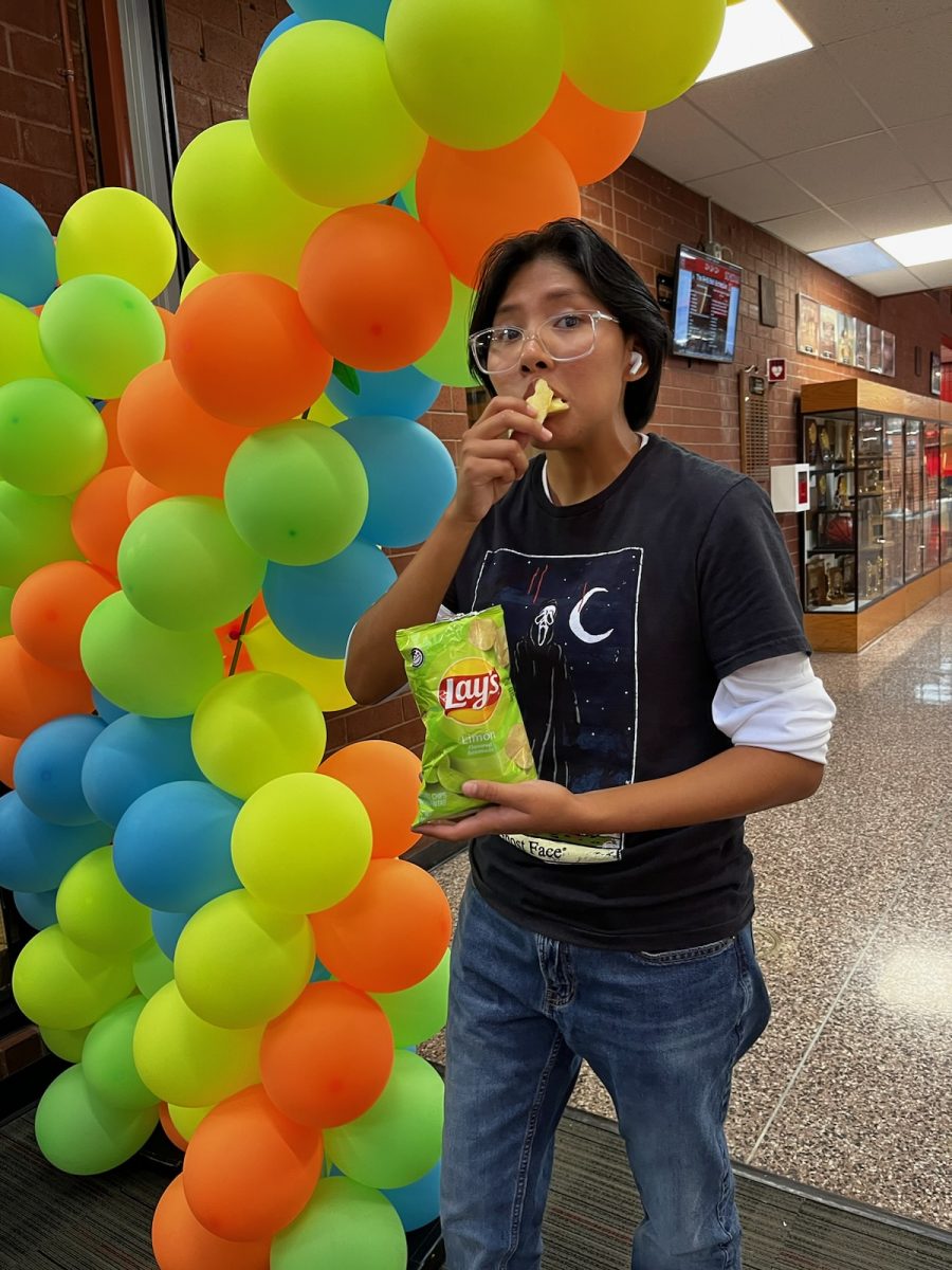 Rangeview Junior Kai Jesus eats a bag of the most delicious Limon Lays chips in the halls of RHS. 